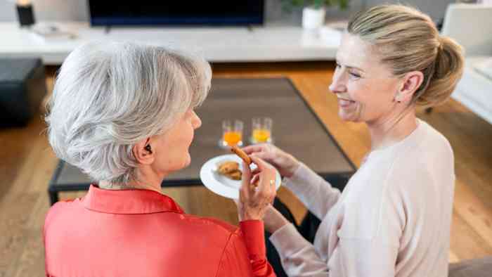 Mère et fille partageant une collation sur le canapé