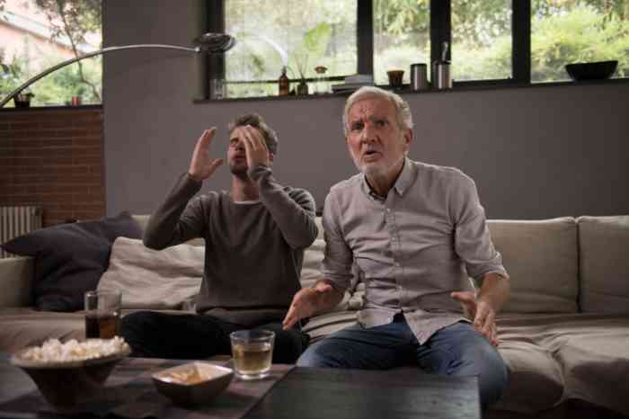 A Grandson and his Grandpa watching a football match on TV