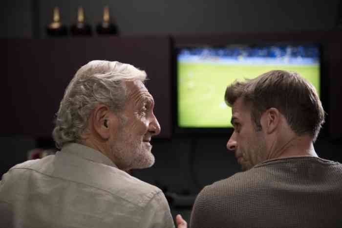grandpa and nephew watching a football match.