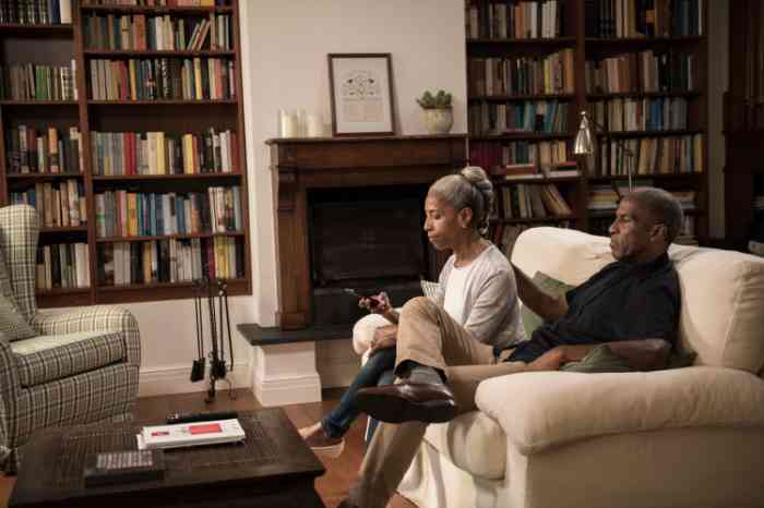 A couple is sitting on their sofa, concerned