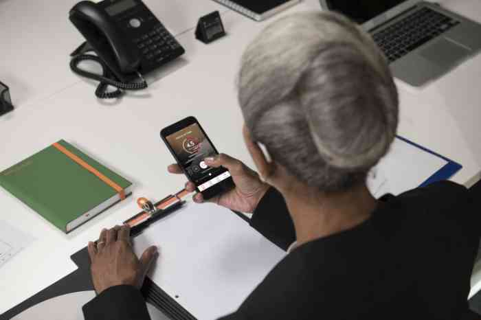 A woman upgrades her digital hearing aid via smartphone