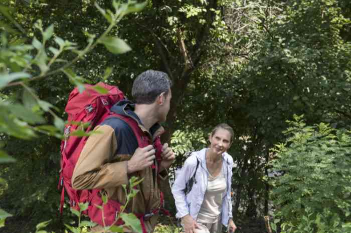 Biking around through the nature A man wearing his hearing aid and a woman walking through the trees