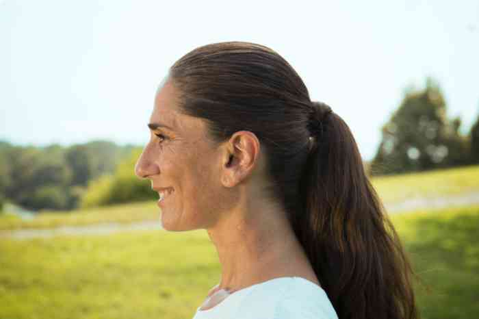 A smiley woman enjoying the countryside's sounds