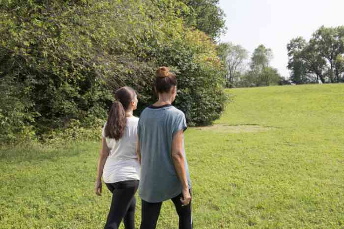 Two friends, wearing hearing aids, walking through the nature