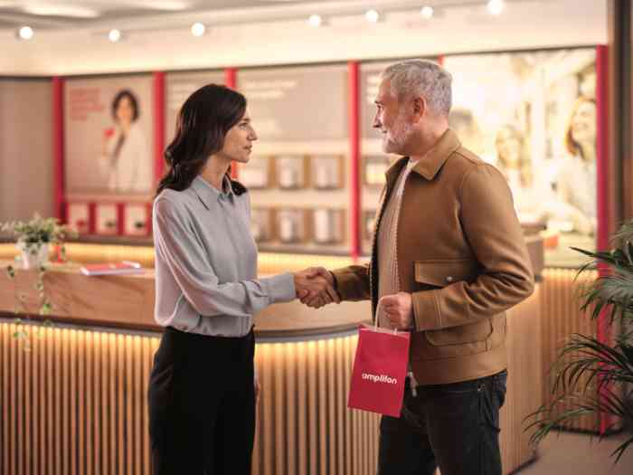 homme saluant l'audiologiste sans blouse dans un magasin Amplifon.