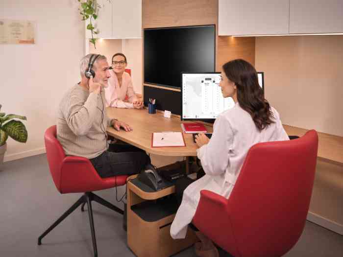 un couple faisant un test auditif avec un audiologiste en blouse.