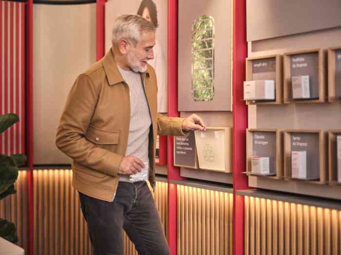 a man recycling old batteries in a designated container at a store in a portuguese store.