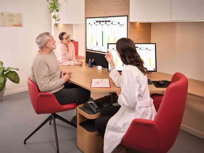 couple examinant les résultats du test auditif avec un audiologiste en blouse.