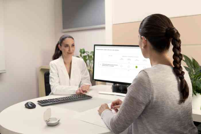 Femme avec une aide auditive BTE parlant avec une experte Amplifon