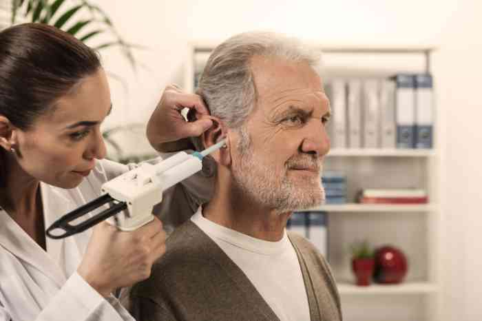 A woman in a coat examines an elderly man.