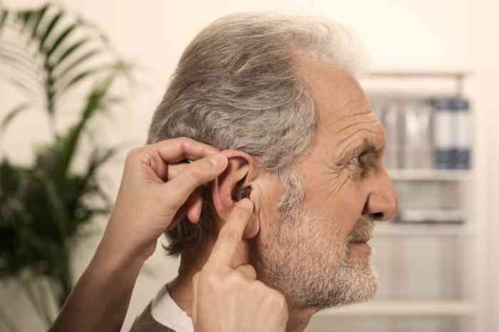 A man is having an ITE hearing aid placed in his ear.