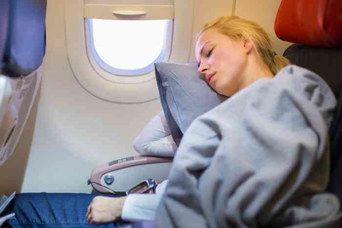 woman sleeping on a pillow during a flight.