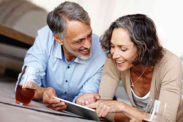 couple smiling while reading a book.