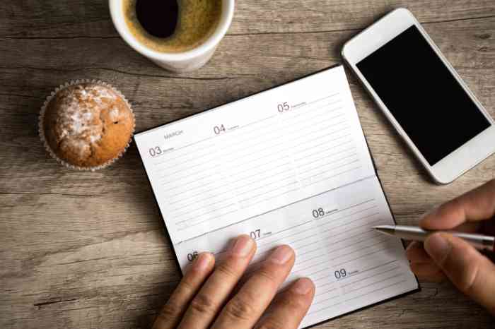table with a notebook, phone, and coffee.