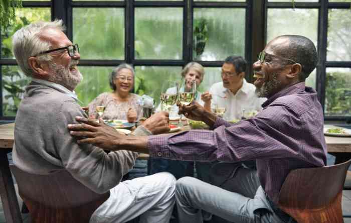 five friends laughing while sitting at a table.