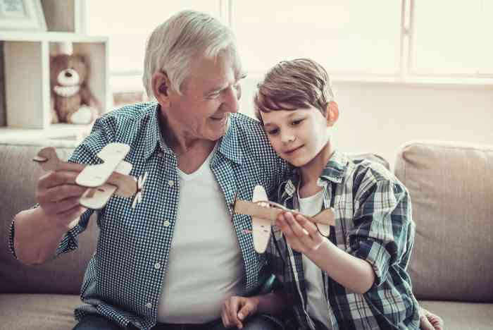 grand-père et petit-fils jouant avec des avions en papier.