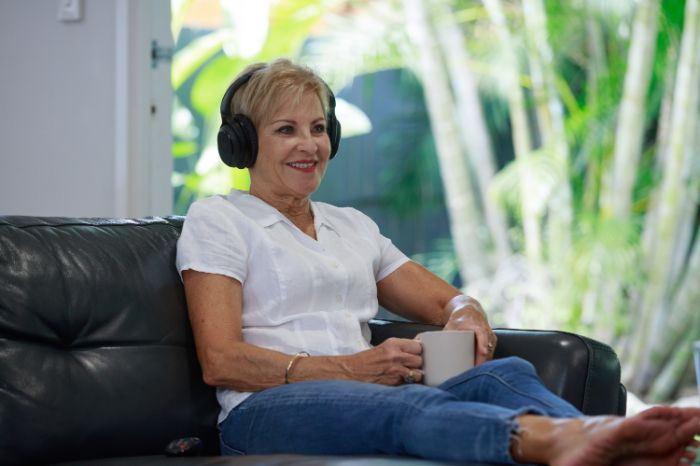 Femme sur un canapé avec des écouteurs