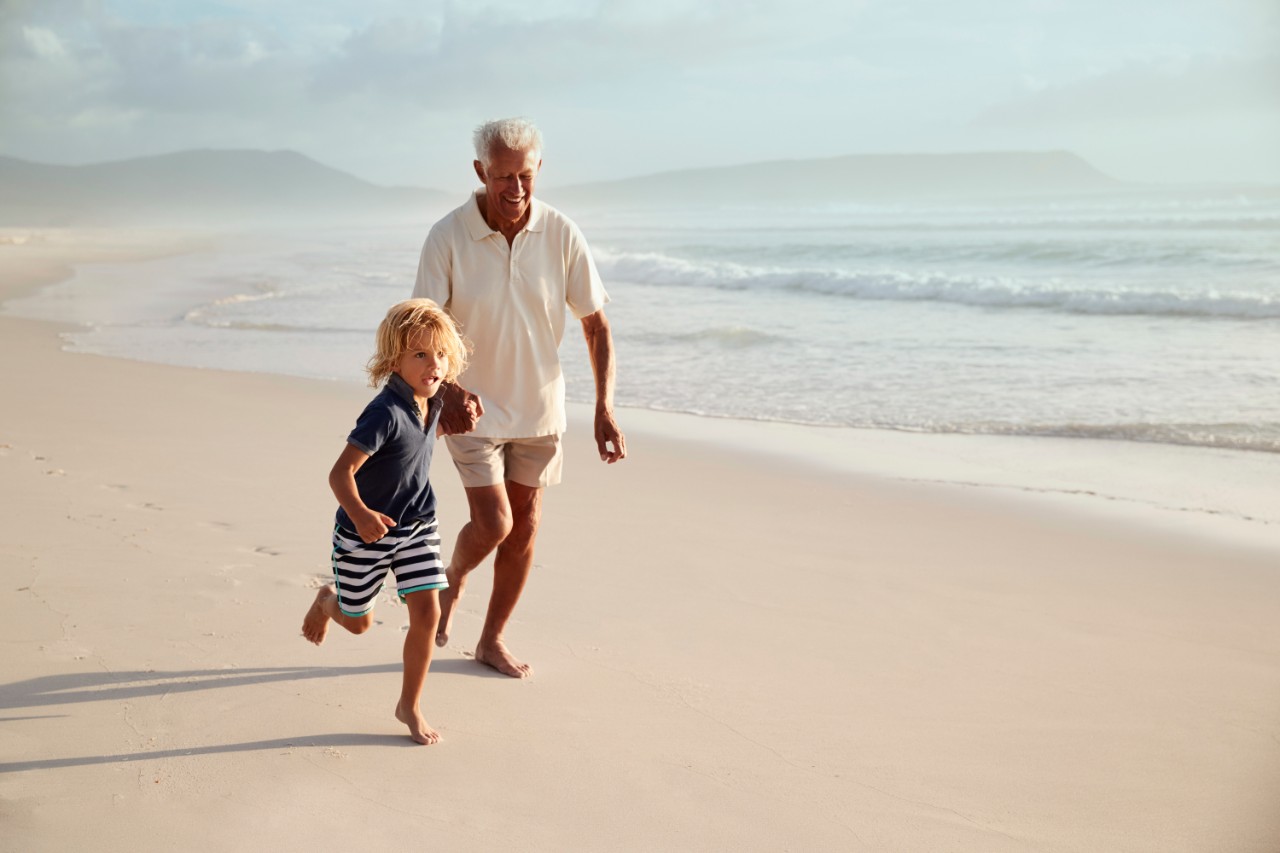 Grand-père et petit-fils courant sur la plage
